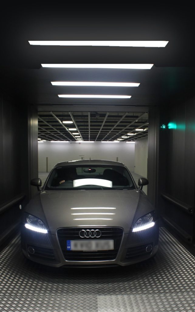Car parked inside a lit car lift