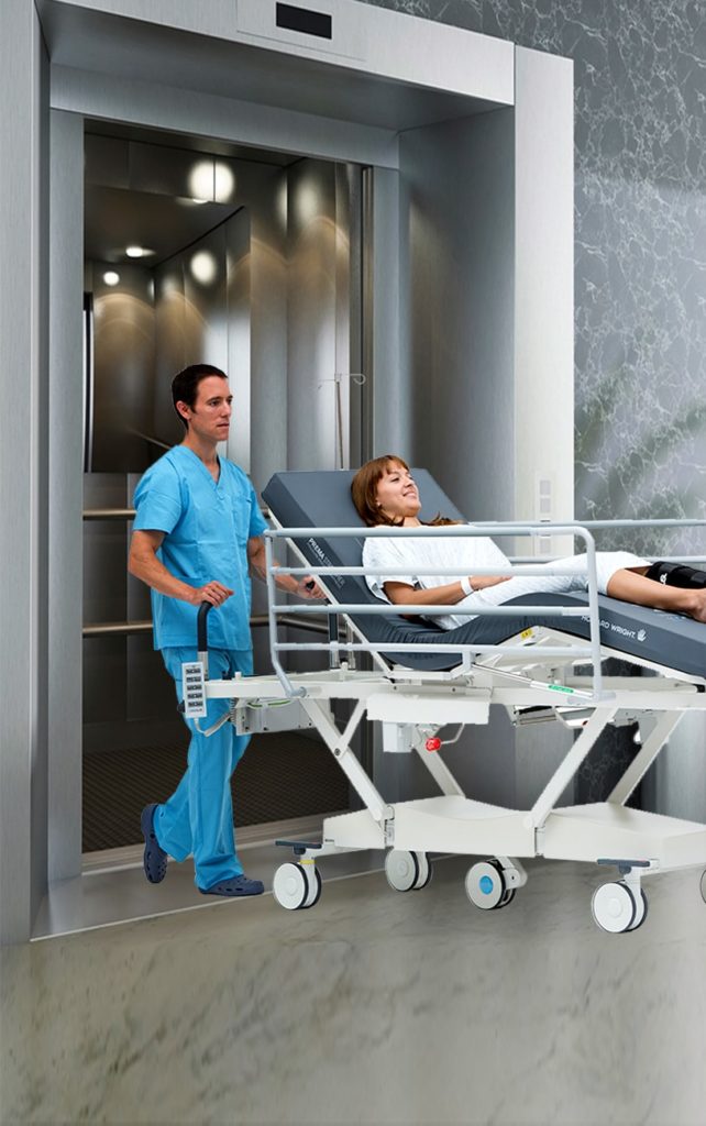 Hospital staff moving a patient on a stretcher into a lift